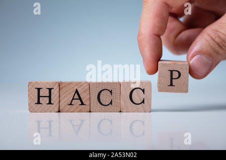 Hand Anordnen von HACCP Holzklötze auf Tisch Stockfoto