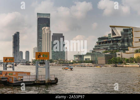 Die Stadt Bangkok, Thailand - 17. März 2019: Si Phraya Ferry Pier am Chao Phraya Fluss mit hgh Gebäude auf der gegenüberliegenden Seite unter blau-weiße cloudscap Stockfoto