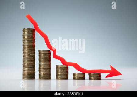 Abnehmende Graph aus gestapelten Münzen über grauer Hintergrund Stockfoto