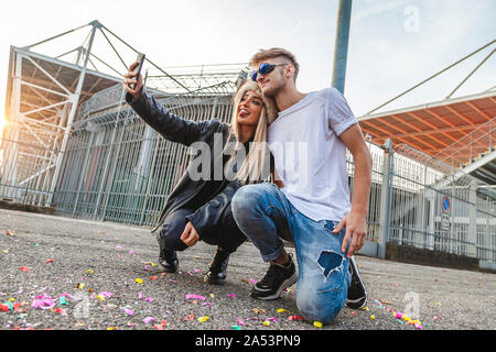 Paar der jungen schönen Liebhaber ein selfie auf dem großen Platz von einem Stadion Stockfoto