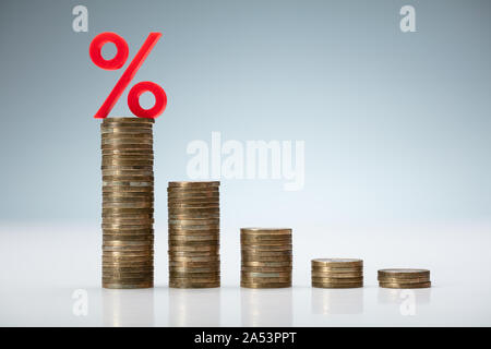 Zinssatz abnehmende Graph aus gestapelten Münzen Stockfoto