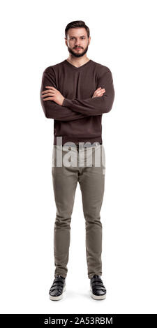 Ein bärtiger Mann im casual Gewand steht in der Vorderansicht mit verschränkten Armen und neutralen Gesichtsausdruck. Stockfoto