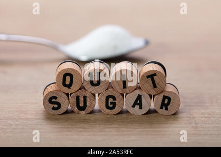 Beenden Sie Zucker Worte in der Nähe von Löffel Zucker auf Tisch Stockfoto