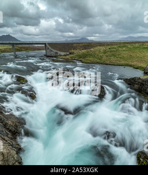 Ein vertikaler rauschende Stromschnellen unterhalb einer Brücke in Island Stockfoto