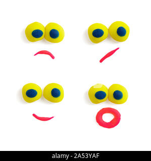 Vier lustige Gesichter - Augen und Mund - aus bunten Knetmasse mit unterschiedlichen Ausdrücke auf dem weißen Hintergrund. Stockfoto