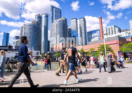 Toronto, Ontario, Kanada - 2019 06 30: Torontonians und Touristen zu Fuß entlang der Promenade in der Harbourfront Toronto vor Hochhäuser Stockfoto