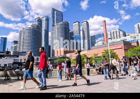 Toronto, Ontario, Kanada - 2019 06 30: Torontonians und Touristen zu Fuß entlang der Promenade in der Harbourfront Toronto vor Hochhäuser Stockfoto