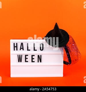Halloween themed Kino Leuchtkasten auf der hellen orange Hintergrund mit lustigen Hexe Hut. Quadratische Format Stockfoto