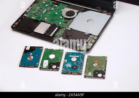 Ein Haufen verwendet HDD neben einem offenen zerlegt Laptop oder Notebook mit SSD ersetzt. Stockfoto