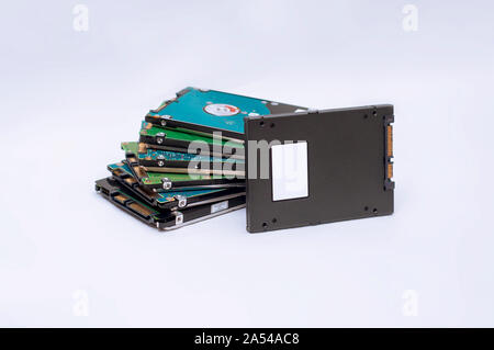 Stapel von HDD mit einer SSD. Stapel der alten Festplatten platziert neben der neuen und schnelleren Solid State Drive. Weiß isoliert Hintergrund. Stockfoto