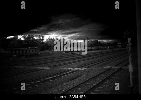 Ein bunter Sonnenaufgang über einem kleinen Bahnhof in Thailand Stockfoto