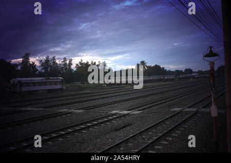 Ein bunter Sonnenaufgang über einem kleinen Bahnhof in Thailand Stockfoto