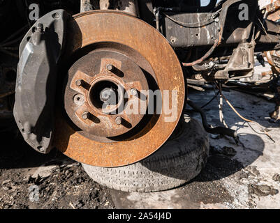 Eine Nahaufnahme auf die alte rostige Bremsanlage eines Autos mit der Bremsbeläge, der Scheiben, Bremssättel in einen Aufzug in einem Fahrzeug Werkstatt. Auto Service Industrie. Stockfoto