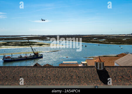 Blick vom Glockenturm der Kathedrale von Faro (Kirche von Santa Maria) mit einem Flugzeug Landung am Flughafen Faro, Algarve, Portugal Stockfoto