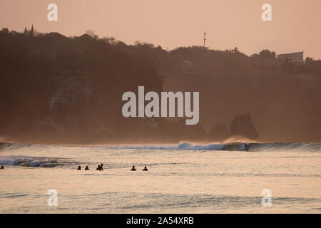 Surfer reiten ein flaches Riff wave in Bingin auf der Halbinsel Bukit, Bali Stockfoto