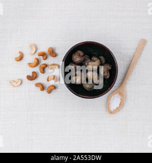 Rohe Cashewnüsse Nuss in der Schüssel mit Salz auf weißen Tisch. Stockfoto