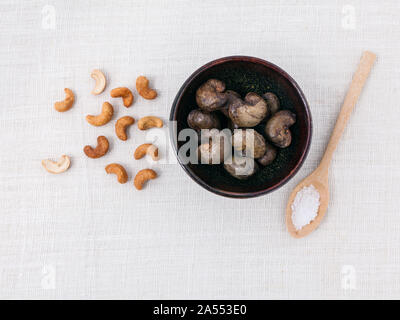 Rohe Cashewnüsse Nuss in der Schüssel mit Salz auf weißen Tisch. Stockfoto