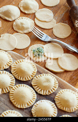 Die Ravioli mit Ricotta und Spinat auf einem Holzbrett Stockfoto