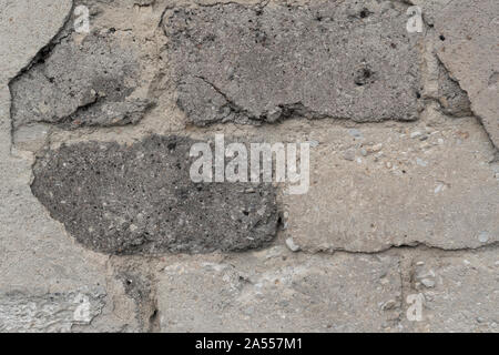 Alte ruiniert graue Wand aus Ziegeln und Zement, Gips. Das Konzept der mit der Zeit brechen Grundlagen Stockfoto