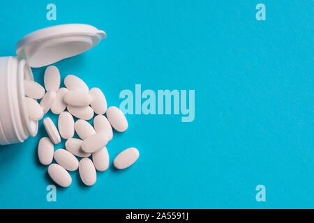 Weiße medizinische Pillen auf blauem Hintergrund, die Health Care Konzept Stockfoto