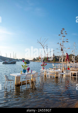 Gümüslük, Bodrum, Türkei - 26. September 2019: Yachten und Restaurants an der Ägäischen Küste in der Ortschaft Gümüslük in der Türkei auf der Halbinsel Bodrum Stockfoto