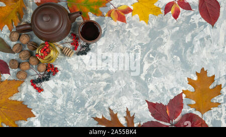 Flach herbst Zusammensetzung der Blätter im Herbst, esche Berry und Tee mit Honig auf Pastell grauer Hintergrund, Ansicht von oben mit der Kopie Raum Stockfoto