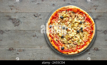 Texturierte Holztisch mit vier Jahreszeiten Pizza auf dem Teller. Ansicht von oben Stockfoto