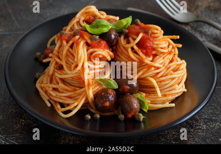 Pasta alla puttanesca - Spaghetti mit Tomatensauce Oliven und Kapern Stockfoto