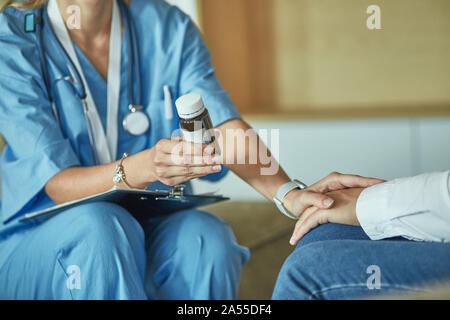 Schöne lächelnde Frau der Arzt in einer Flasche Pille bietet den Patienten Stockfoto