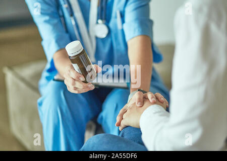 Schöne lächelnde Frau der Arzt in einer Flasche Pille bietet den Patienten Stockfoto