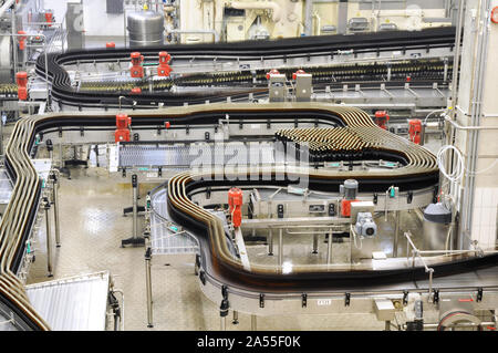 Moderne Fabrik in der Lebensmittelindustrie - Bier Brauerei - Transportband mit Bierflaschen und Maschinen für die Produktion Stockfoto