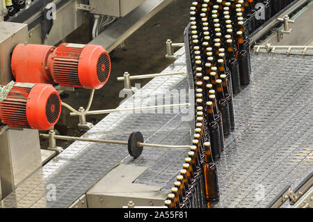 Bier Flaschen auf dem Fließband in einer modernen Brauerei - Anlagen in der Lebensmittelindustrie Stockfoto