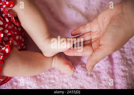 Der schöne kleine Baby Beine eine glückliche Mutter Stockfoto