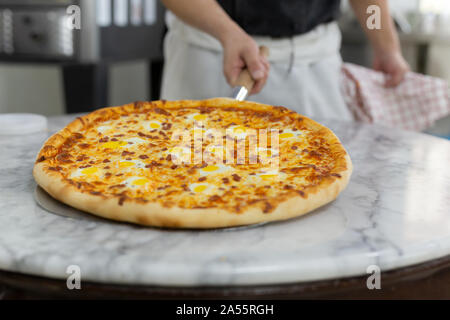 Köche Hand Pizza Hawaii auf Holzbrett. Stockfoto