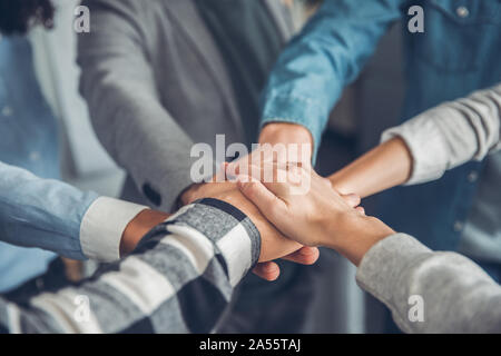Startupers arbeiten im Büro gemeinsam Hand in Hand close-up Motivation Stockfoto