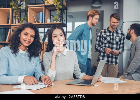 Startupers zusammen arbeiten im Büro Frauen am Tisch sitzen auf der Suche Kamera lächelt glücklich Stockfoto