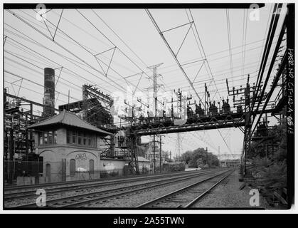 Blick auf Anker Brücke Nr. 310 auf der Suche nach Westen entlang der Strecke nördlich der Cos Cob Kraftwerk befindet. Turm der Ladung Dispatcher ist links im Vordergrund angezeigt. An dieser Station der Dispatcher kontrollierte Leistung zu den verschiedenen Teilen des Systems. Die Struktur dient dem gleichen Zweck 1993 und kann lokal oder im Remote-Zugriff von der Metro-North Hauptsitz in Manhattan betrieben werden. Der Stahlbau- und im Hintergrund Stack sind Teil der Kessel 902-903 Installation. - New York, New Haven und Hartford Railroad, Cos Cob-Kraftwerk, Sound Shore Drive, Greenwich, Fairfield Zählen Stockfoto