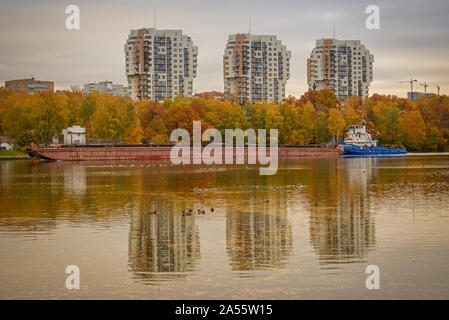 Chimki, Russland - Oktober 10, 2019: Das Schiff ist das Segeln entlang der Moskauer Canal in der Nähe der Stadt Chimki gegen das Ufer mit Häusern und Gelb Herbst Stockfoto