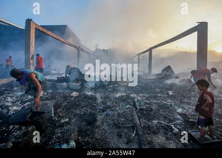 Navotas City, Philippinen. Okt, 2019 18. Bewohner Blick für Ihre Habseligkeiten durch ihre Verkohlten Wohnungen nach einem Brand in einem Wohngebiet im Navotas City, Philippinen, Okt. 18, 2019. Nach den Navotas Stadt Katastrophenvorsorge Management Office, rund 200 Baracken waren im Feuer zerstört. Credit: rouelle Umali/Xinhua/Alamy leben Nachrichten Stockfoto