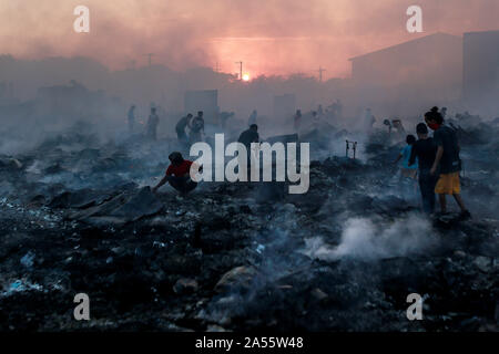 Navotas City, Philippinen. Okt, 2019 18. Bewohner Blick für Ihre Habseligkeiten durch ihre Verkohlten Wohnungen nach einem Brand in einem Wohngebiet im Navotas City, Philippinen, Okt. 18, 2019. Nach den Navotas Stadt Katastrophenvorsorge Management Office, rund 200 Baracken waren im Feuer zerstört. Credit: rouelle Umali/Xinhua/Alamy leben Nachrichten Stockfoto