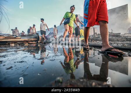 Navotas City, Philippinen. Okt, 2019 18. Bewohner Blick für Ihre Habseligkeiten durch ihre Verkohlten Wohnungen nach einem Brand in einem Wohngebiet im Navotas City, Philippinen, Okt. 18, 2019. Nach den Navotas Stadt Katastrophenvorsorge Management Office, rund 200 Baracken waren im Feuer zerstört. Credit: rouelle Umali/Xinhua/Alamy leben Nachrichten Stockfoto