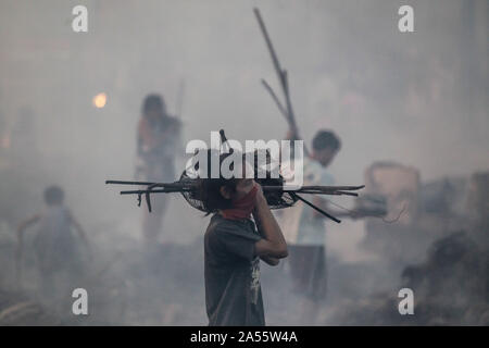 Navotas City, Philippinen. Okt, 2019 18. Bewohner Blick für Ihre Habseligkeiten durch ihre Verkohlten Wohnungen nach einem Brand in einem Wohngebiet im Navotas City, Philippinen, Okt. 18, 2019. Nach den Navotas Stadt Katastrophenvorsorge Management Office, rund 200 Baracken waren im Feuer zerstört. Credit: rouelle Umali/Xinhua/Alamy leben Nachrichten Stockfoto