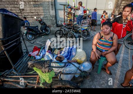 Navotas City, Philippinen. Okt, 2019 18. Bewohner Rest mit ihren Habseligkeiten entlang einer Straße nach einem Brand in einem Wohngebiet im Navotas City, Philippinen, Okt. 18, 2019. Nach den Navotas Stadt Katastrophenvorsorge Management Office, rund 200 Baracken waren im Feuer zerstört. Credit: rouelle Umali/Xinhua/Alamy leben Nachrichten Stockfoto