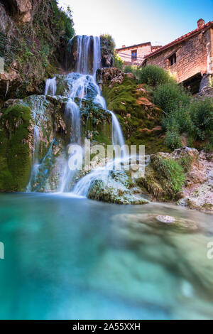 Berühmten Wasserfälle mit seideneffekt mit einer kristallinen Wasser läuft zwischen den Häusern und fließt der Fluss Ebro in Orbaneja del Castillo (Burgos Stockfoto