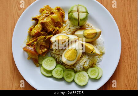 Gekochten süßen braunen Ei und würzig gebratenem Wildschwein Red Curry auf Reis rühren Stockfoto