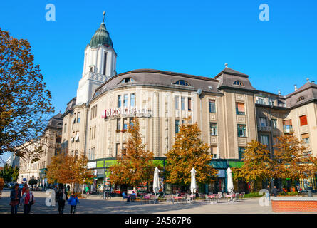 Hatvan US (Straße) in der Innenstadt von Debrecen mit einem Assicurazioni Generali Büro Gebäude und Bäume im Herbst Farben. Debrecen, Ungarn. Stockfoto