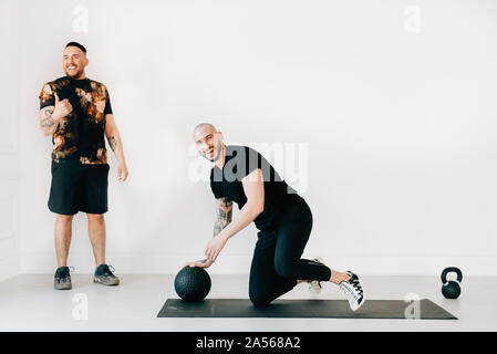 Mann Daumen bis zu Fitness Instructor im Studio Stockfoto