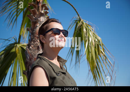 Schönes Portrait von mittleren Alters ältere Frau im Urlaub. Lifestyle schoss der weiblichen mit Sonnenbrille und genießen Sommer Sonne am Strand im Sommer Stockfoto