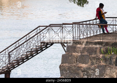 Fort Vellore umgeben von Wasser, die Treppe hinunter zum Wasser und die Menschen, die interagieren und sie ihr Smartphone - Indien 2019 Stockfoto