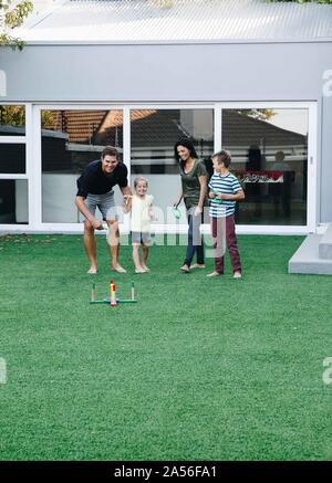 Eltern und Kinder spielen Ring auf Rasen werfen Stockfoto